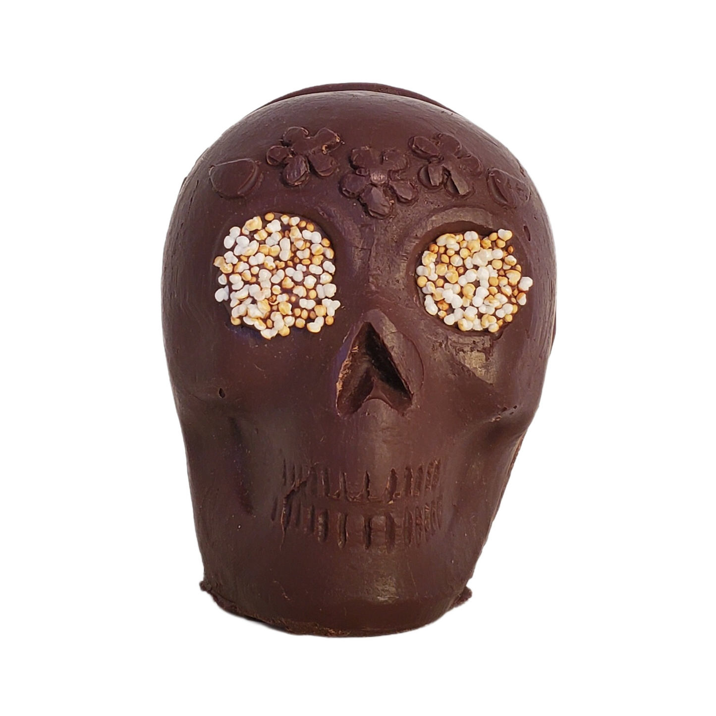 Chocolate skull figurine with white popped amaranth eyes and a flower headband decoration.