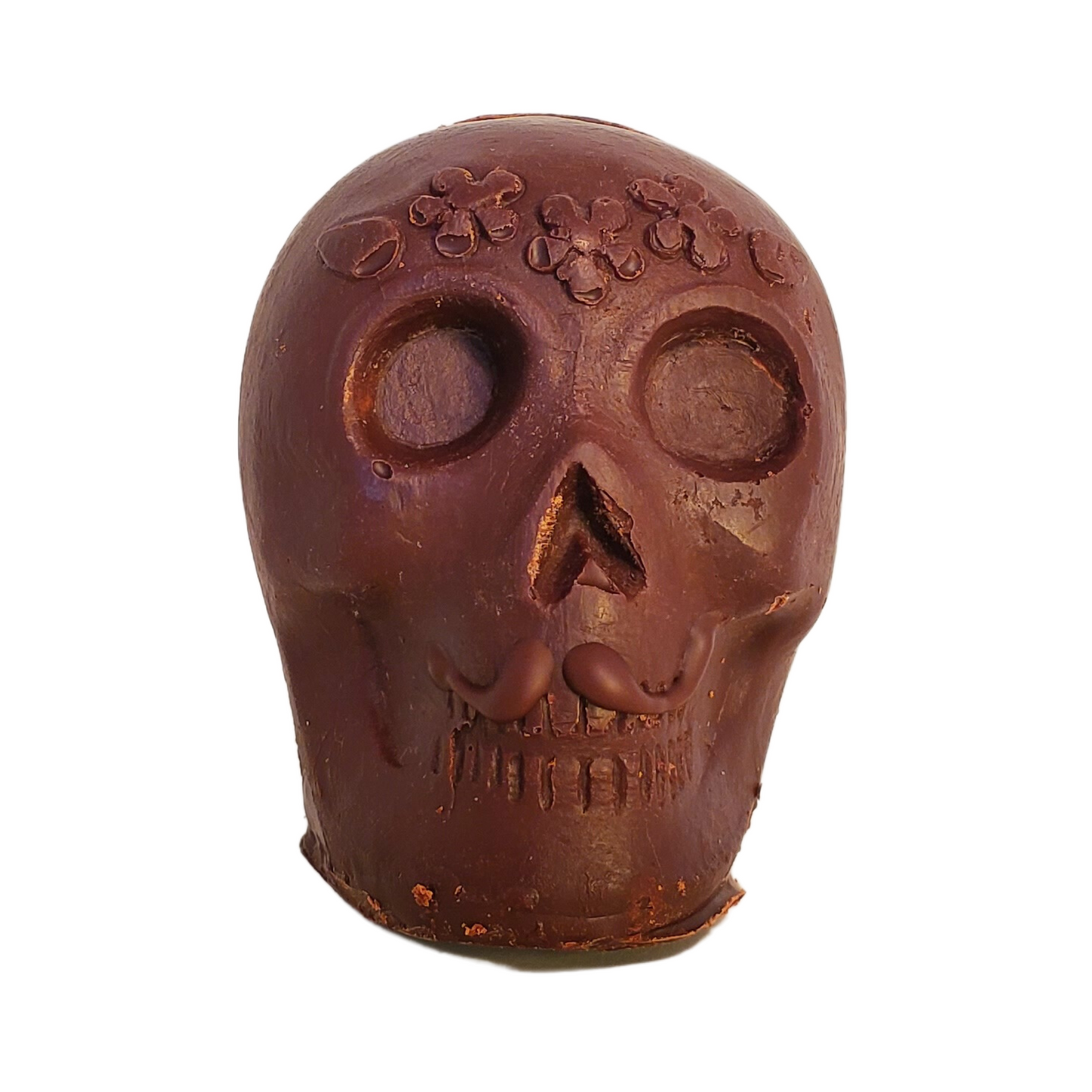 Chocolate skull figurine with a chocolate moustache and flower headband decoration.